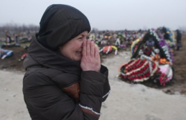 Người thân của nạn nhân thiệt mạng do trúng pháo khóc thương tại một nghĩa trang ở thành phố cảng Mariupol, Ukraine, 27/1/2015