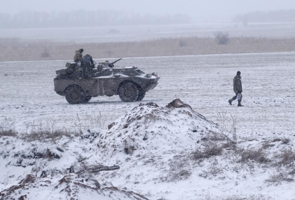 Một người lính Ukraine xách nước mang ra chiếc xe đang đỗ trên một cánh đồng gần đường giữa các thị trấn Debaltseve và Artemivsk, Ukraine, Thứ 2 16 Tháng 2, 2015.