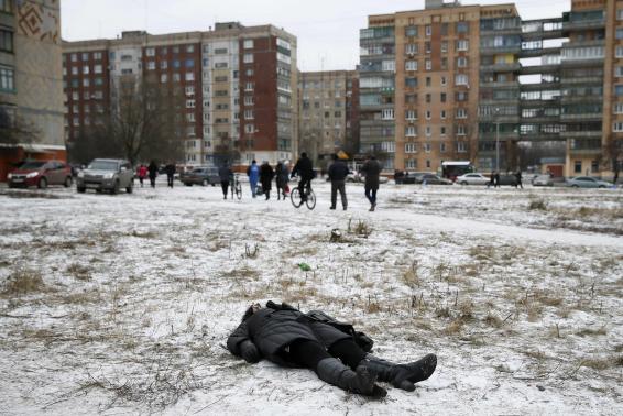 The body of a woman killed by recent shelling lies on a street in the residential sector in the town of Kramatorsk