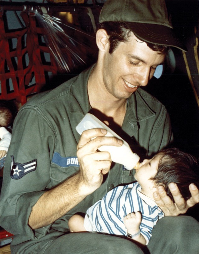 Một quân nhân Mỹ chăm sóc trẻ em Việt Nam trong chuyến bay rời Sài Gòn. Sau này, chương trình Babylift trở thành chủ đề tranh cãi và chỉ trích từ chính dư luận Mỹ. Ảnh: DIA.mil