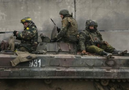 Members of the Ukrainian armed forces ride on an armoured personnel carrier near Artemivsk