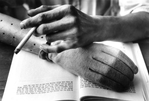 Một người Việt đọc sách, hút thuốc bên cánh tay giả, tháng 8/1968. (AP/ The Atlantic)