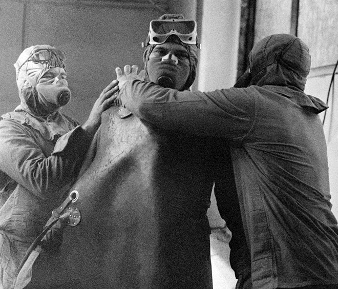 Nhân viên tham gia quá trình khắc phục hậu quả thảm họa phải đeo mặt nạ chống độc. Ảnh: RIA Novosti