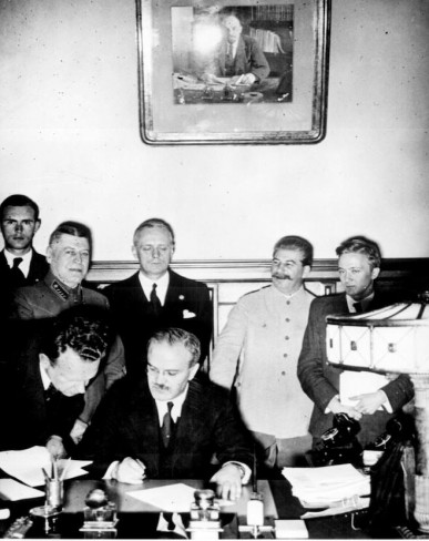Ngoại trưởng Vyacheslav Molotov trong lễ ký Hiệp ước  Ribbentrop-Molotov dưới sự chứng kiến của Stalin (Moscow Times)