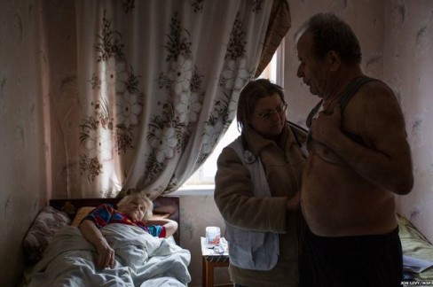 Bác sĩ Svetlana Niekurasa, người đã lựa chọn ở lại thị trấn trong cuộc xung đột, đang kiểm tra sức khỏe cho ông Ivan Vorobyeva, 74 tuổi. Ông đang một mình chăm sóc người vợ ốm yếu tại nhà riêng trong  Debaltseve