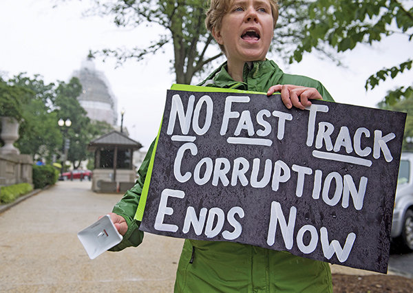 A demonstrator protests against the legislation to give US President Barack Obama fast-track authority to advance trade deals, including the Trans-Pacific Partnership (TPP), during a protest march on Capitol Hill in Washington, DC, May 21, 2015. The US Senate advanced the legislation on Thursday to give Obama fast-track authority to forge a huge Asia-Pacific trade accord, setting up a final vote in the chamber for later this week. The measure would allow the Obama administration to conclude negotiations with 11 other Pacific Rim nations and bring a trade accord to Congress for an up or down vote, with lawmakers not permitted to make changes. AFP PHOTO / SAUL LOEB