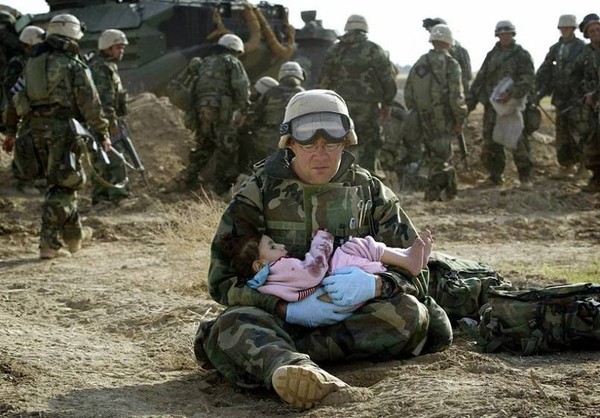 Vẻ mặt mệt mỏi xen lẫn nhẹ nhõm hiện trên khuân mặt của một người lính hải quân Mỹ khi đã cứu được một cô bé bị lạc mất gia đình trong chiến tranh tại Iraq vào năm 2003.