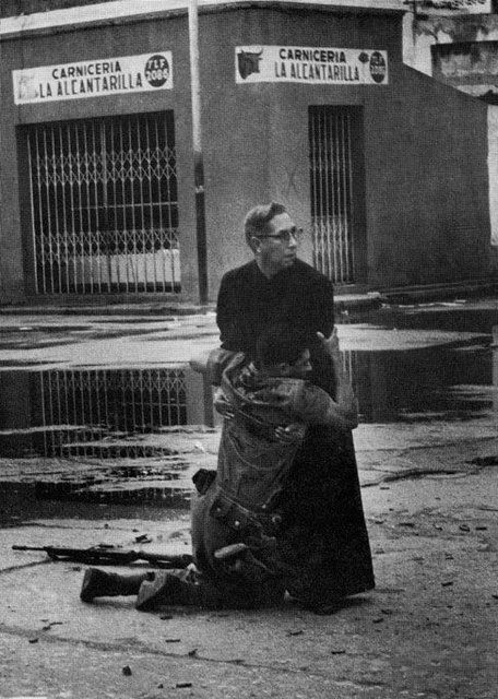 Vị linh mục đang an ủi một người lính bị thương gục ngã trên tay ông sau khi phải chứng kiến quá nhiều cái chết của các đồng đội.