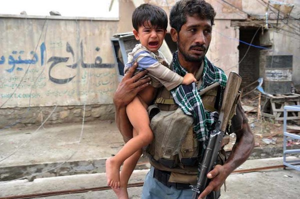 Người lính Afghanistan giải cứu một em bé đang khóc vì sợ hãi ra khỏi hiện trường một vụ nổ trong cuộc chiến tranh Afghanistan (2001-2014).