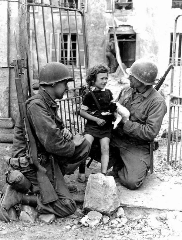 Hai người lính Mỹ đang cố gắng đem niềm vui đến cho bé gái trong Chiến tranh Thế giới thứ hai.