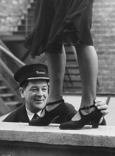 Một nhân viên làm việc ở ga tàu hỏa được giao nhiệm vụ làm giám khảo tại một cuộc thi tìm kiếm Hoa hậu mắt cá chân được tổ chức dành riêng cho những phụ nữ làm việc trong ngành đường sắt Anh hồi năm 1949.