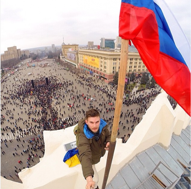 Một người biểu tình ủng hộ Nga thay thế cờ Ukraina bằng một lá cờ Nga trên đỉnh tòa nhà hội đồng thành phố Kharkiv. (Instagram / Vonoru)