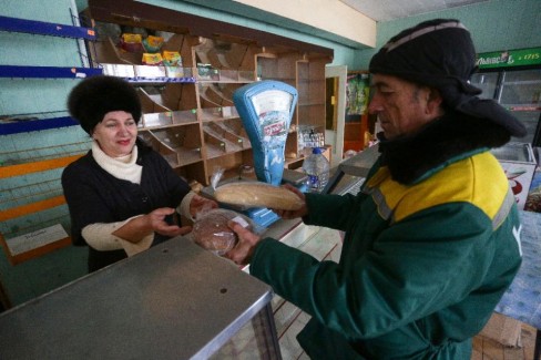 Một người dân nhận đang nhận bánh mì miễn phí của quân đội Ukraina, tại một cửa hàng địa phương ở làng Pavlopil, Donetsk khu vực phía đông của Ukraina (AFP Photo / Aleksey Filippov)