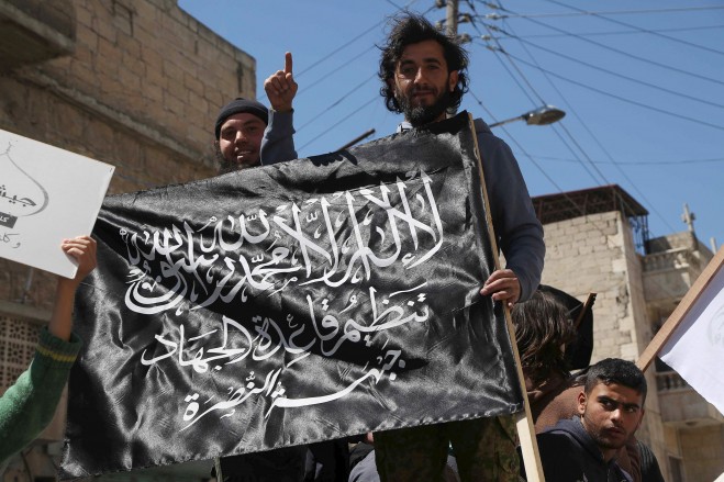 (Hosam Katan / Reuters) Người dân dương lá cờ của Mặt trận Nusra trong một cuộc biểu tình kỷ niệm ngày dành quyền kiểm soát Idlib khoảng một tháng trước đây và kêu gọi thực hiện các luật Hồi giáo Sharia, trong khu phố Al-Sakhour Aleppo 24/04/2015.